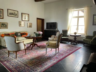 Elegant living room with vintage furniture and a large Persian rug.