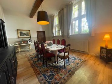 Elegant dining room with red chairs and vintage decor.