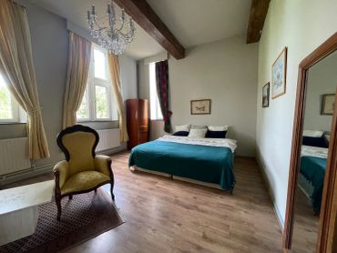 Cozy bedroom with vintage decor and wooden beams.