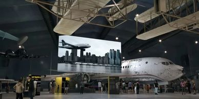 Visitors explore an aviation museum with historic airplanes and exhibits.
