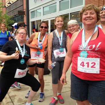 Five women celebrating after completing a race, showcasing the supportive SOL Fitness community.