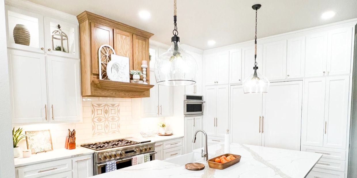 Bright modern kitchen with white cabinets and wooden accents.