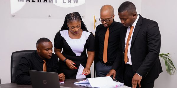 Four professionals collaborating over documents in a law office.