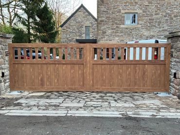 Double aluminium electric gates in golden oak style fitted at a property in the Wirral area.