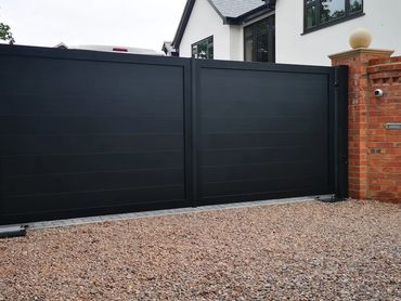 Double aluminium electric gates in black with horizontal board fitted at a home in the Wirral area.