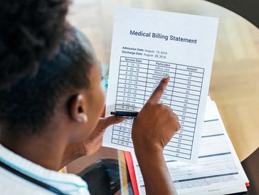 Healthcare costs and fees concept.Hand of smart doctor calculating medical costs in modern hospital.