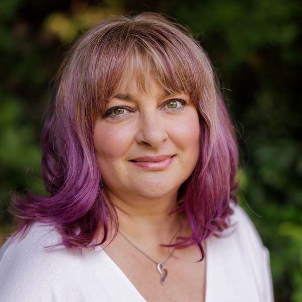 Headshot of Karma Raad, a warm and experienced massage therapist with a friendly and inviting smile.