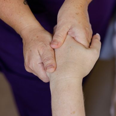 Karma holding a client's hand with both hands