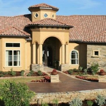 Elegant house entrance with columns and tiled roof.