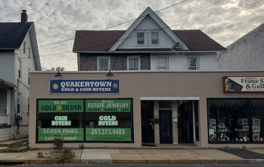 Storefront of Quakertown Gold & Coin Buyers with large green and white signage.