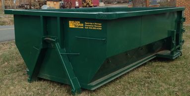 Roll-off dumpster rental. A green open top dumpster at a renovation job site