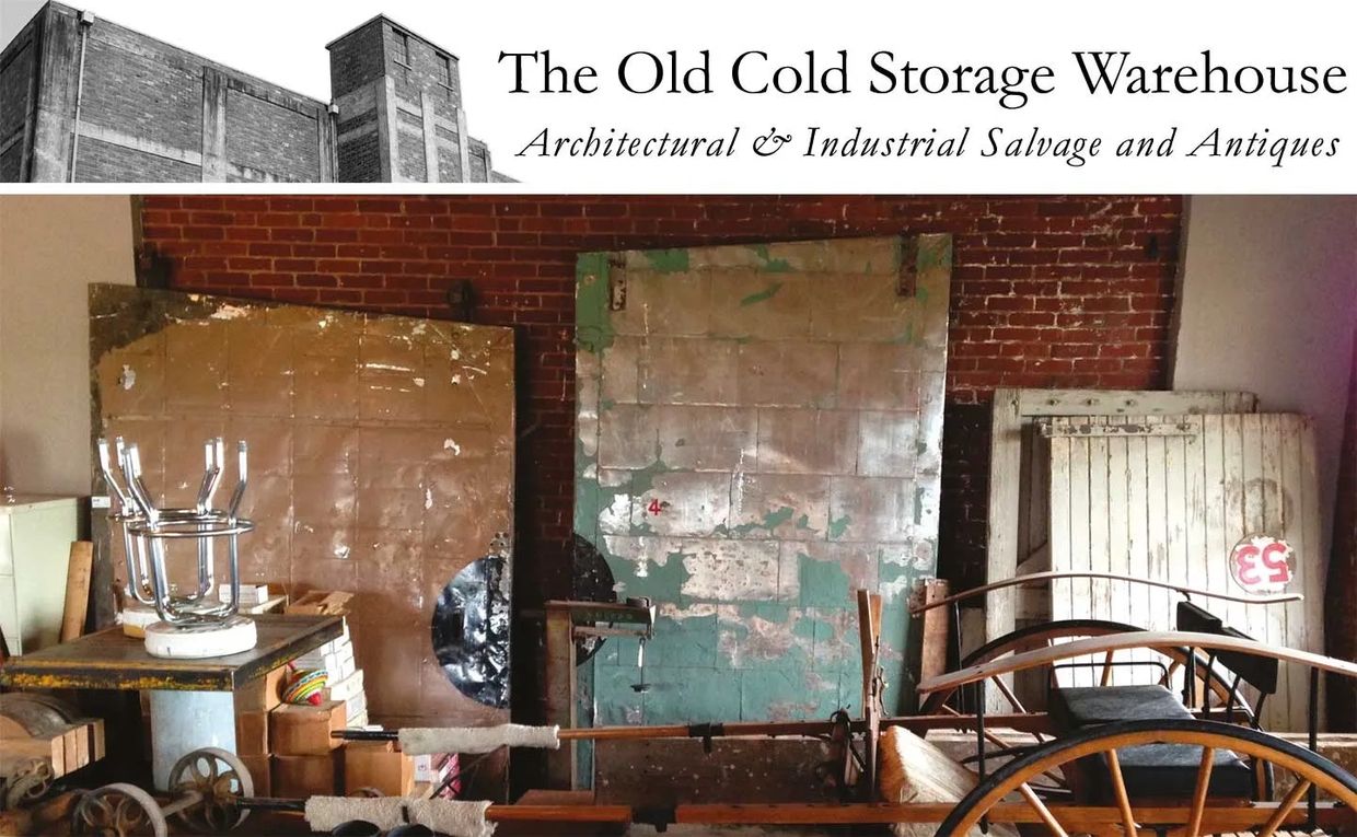 Room full of architectural salvage, warehouse doors, carts, barstools, scales, antique wagon 