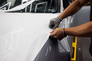 Installing 3M vinyl wrap on hood of a car in Portland, Oregon