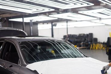 Installer installing 3M vinyl graphics wrap on hood of a car in Portland, Oregon