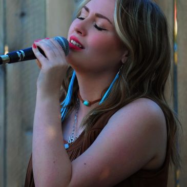 Woman passionately singing into a microphone.