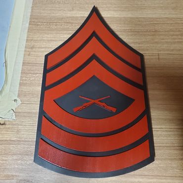 Red and black military rank plaque made from wood.