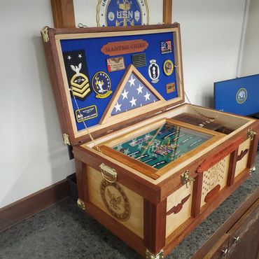 Retirement chest with an engraved lid and a blue-backed memorabilia display.
