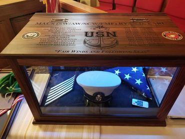 Open wooden retirement chest with a folded flag and service memorabilia.