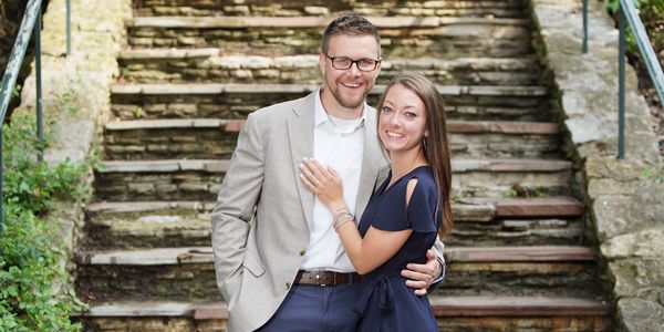 Happy couple posing on stone stairs.