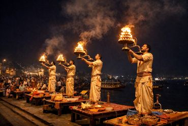 Priests performing a traditional fire ritual by the river at night.