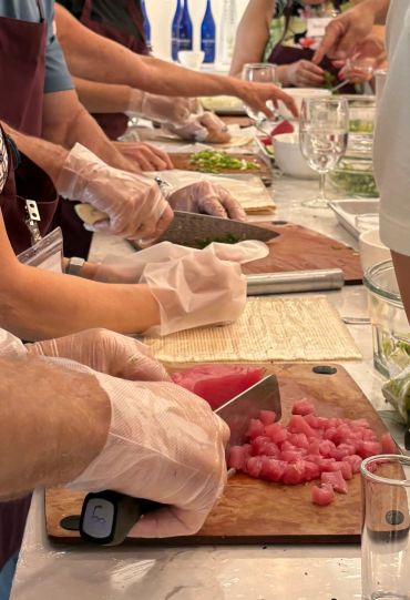 People wearing gloves chopping ingredients at a cooking class.