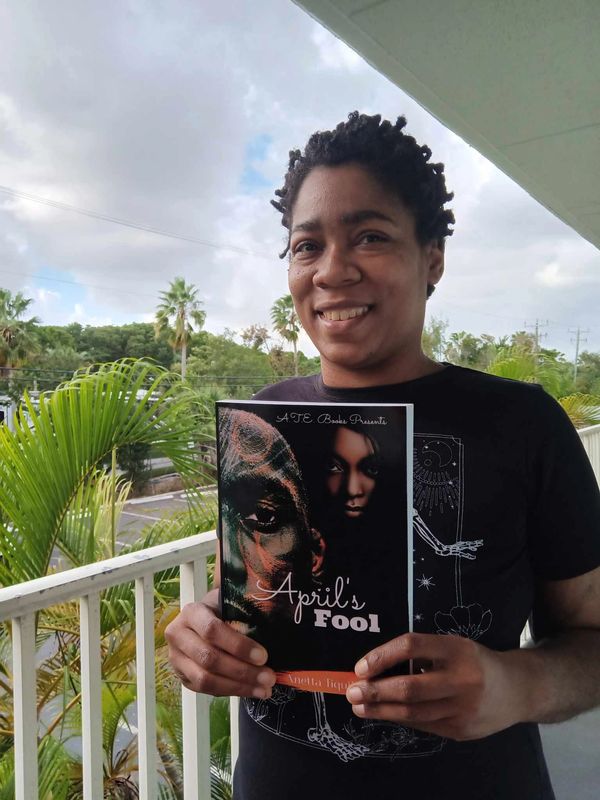 Author on tropical island holding a book