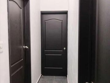A narrow hallway with closed dark wooden doors on both sides.