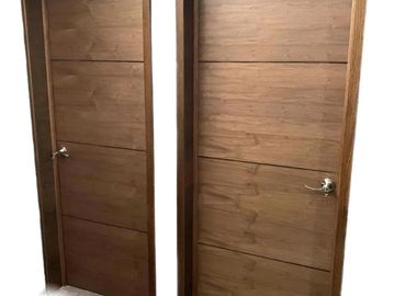 Two wooden interior doors with silver handles in a hallway.