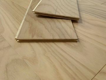 Light wood laminate flooring with two planks stacked on top.