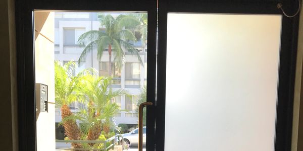 House entrance doors, left side clear without film and right side tinted with frosted window film