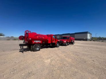 A red truck parked in the middle of an empty lot.