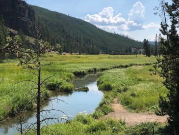 A peaceful mountain valley with a small river.