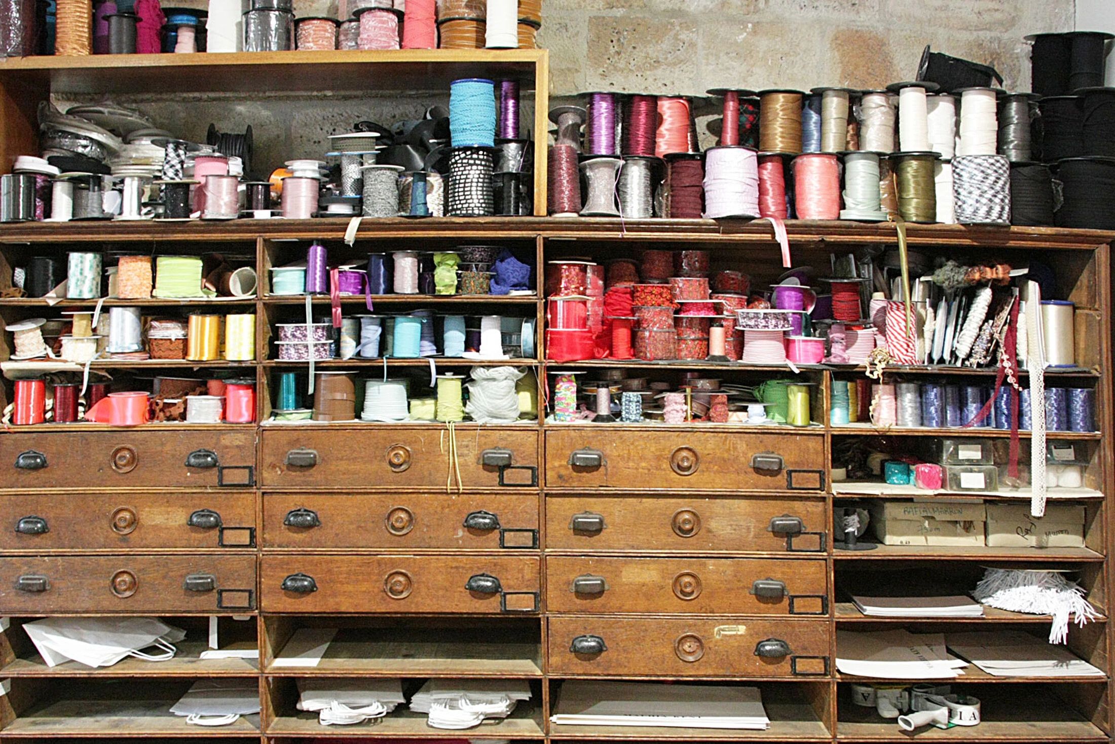 Organized shelves filled with colorful ribbons and threads.