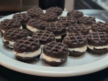 Plate of chocolate sandwich cookies with cream filling.