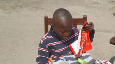 Sheku opening his Christmas Shoebox Gift from friends in the UK