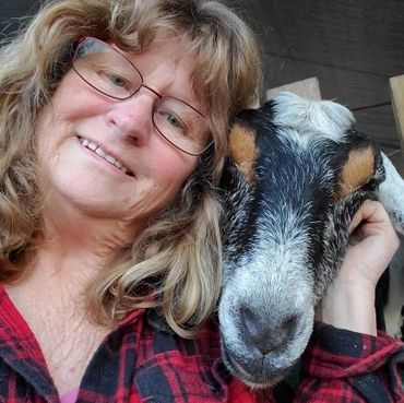 Selfie of an old lady along with a black color goat