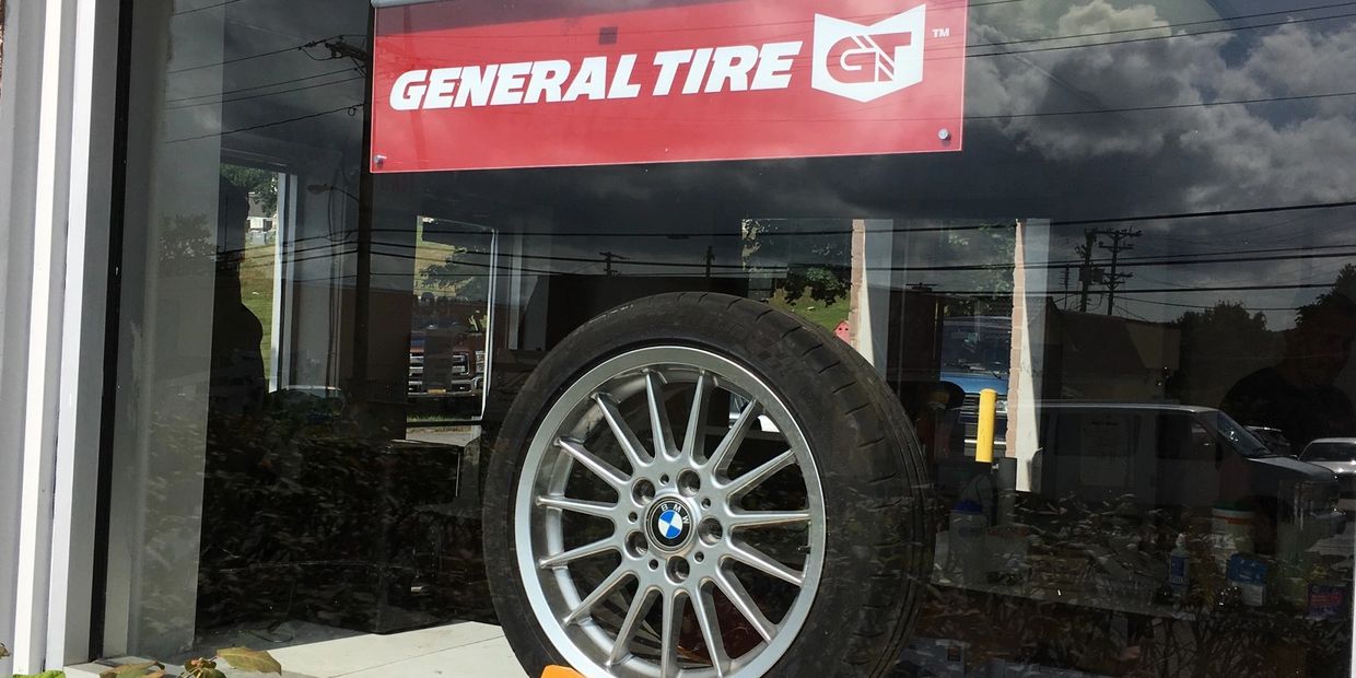 General tire mounted on wheel and logo banner together displaying in store front window