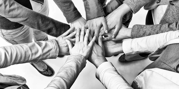 Group of people joining hands in unity.