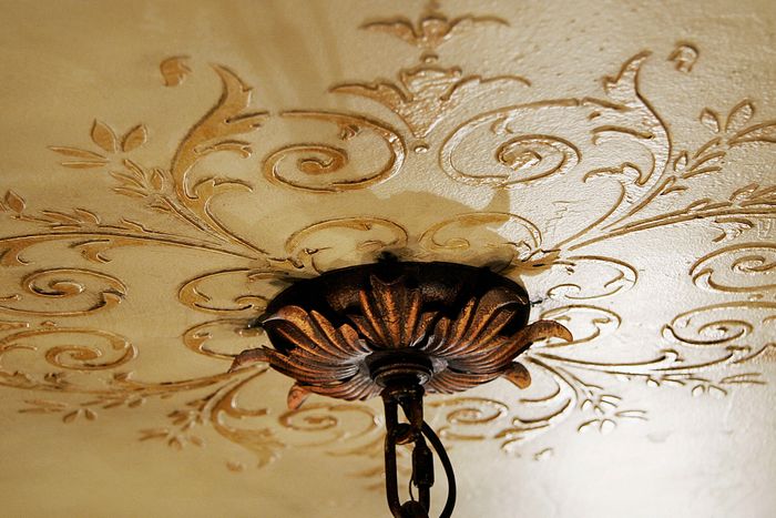 Embossed ceiling medallion with paint and glaze enhancements