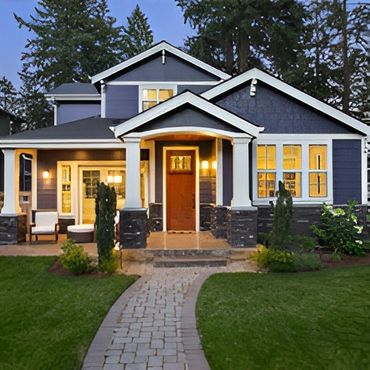Blue house with lit porch.