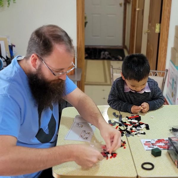 father and son building lego