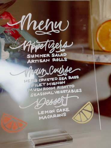 Hand-lettered calligraphy on a acrylic menu sign for a wedding shoot