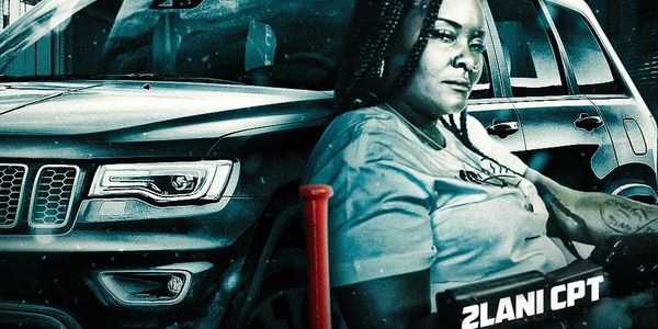 A woman with braids sits beside a black SUV, with a red baseball bat in front.