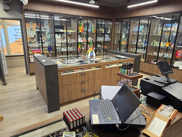 Interior of a modern glass shop with display cabinets and a checkout counter.
