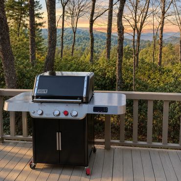 Gas grill on the deck at Woodsong Lake Toxaway Retreat with eastern mountain views, wooded privacy, and outdoor cooking space for seasonal guests.