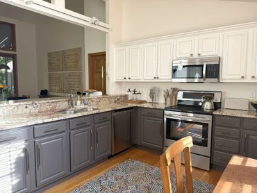 Fully equipped kitchen at Woodsong Lake Toxaway Retreat with stone counters, stainless appliances, natural light, and longer-stay comfort.