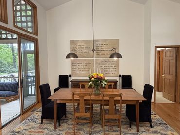 Dining room at Woodsong in Lake Toxaway with warm mountain interiors, a large table, and comfortable space for seasonal stays.