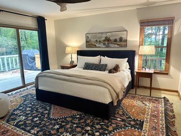 Comfortable bedroom suite at Woodsong Lake Toxaway Retreat with wooded views, restful bedding, and private bath access for seasonal guests.