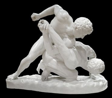 Marble sculpture of two men wrestling in dynamic motion.