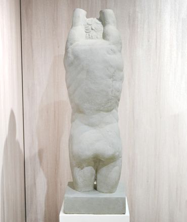 Marble sculpture of a torso without arms and head.